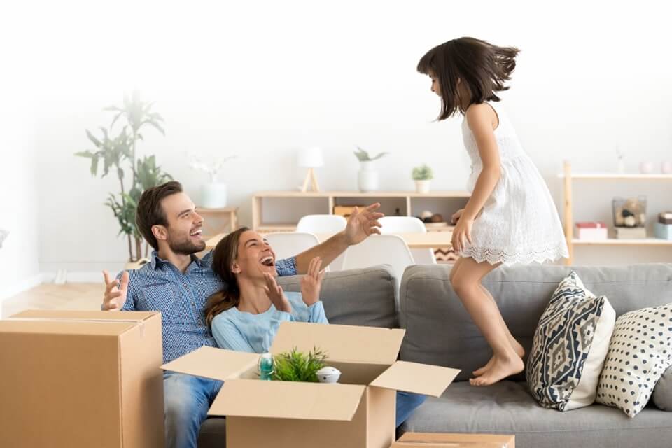 Family smiling in living room with crates